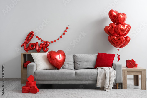 Interior of living room decorated for Valentine's Day with sofa and red balloons