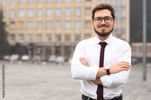 Handsome businessman in eyeglasses on city square