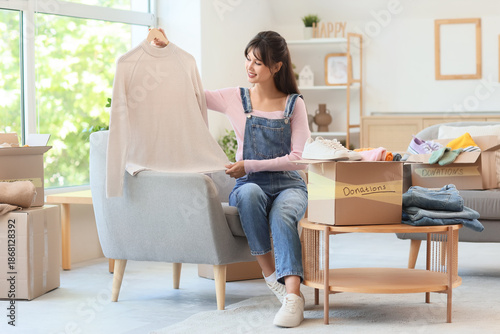 Young woman packing sweater...