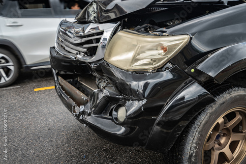 Fotografi Front-end collision damage on a black car with a crumpled hood and shattered bumper after a severe road accident