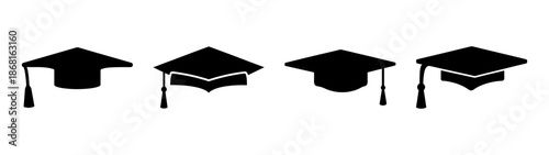 Four black graduation caps with tassels celebrating academic achievement and graduation ceremony