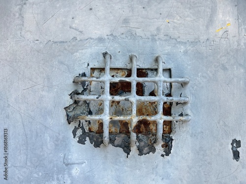 A speakeasy door grille, installed over a small window in a door.