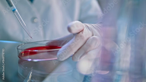 Tablou pe pânză A gloved hand carefully dispenses red liquid into a test tube, symbolizing precision in medical research