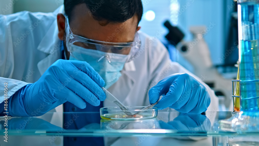Αυτοκόλλητο A scientist in a lab coat and protective gear carefully examines a sample in a petri dish