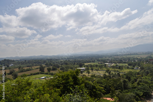 panoramic countryside view with rolling hills, scattered houses and fluffy white clouds, Khao Yai, Thailand