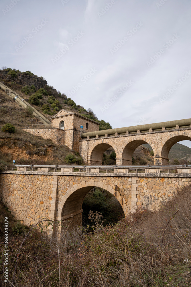 Fototapeta premium Historic stone bridge structure in a mountainous area.. Pueblo de Patones de Arriba in Madrid, known for its slate architecture and for evading the French invasion.