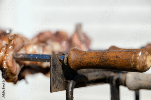Traditional Cypriot food souvla. Spit-roasted chicken and lamb cooking on coal.