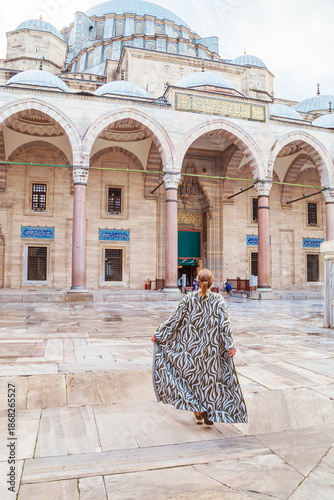 Woman in a traditional oriental robe in the courtyard of the Suleymaniye Mosque.