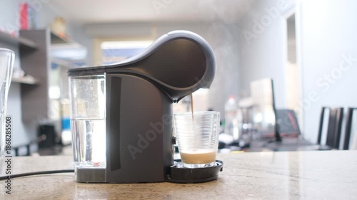 Automatic coffee maker preparing a hot drink with visible coffee stream, showcasing convenient home or office coffee brewing.