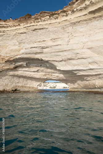 Limestone rock arch along the Mediterranean coast with clear seawater below, shaped by erosion into a striking natural formation that highlights coastal geology and textures.