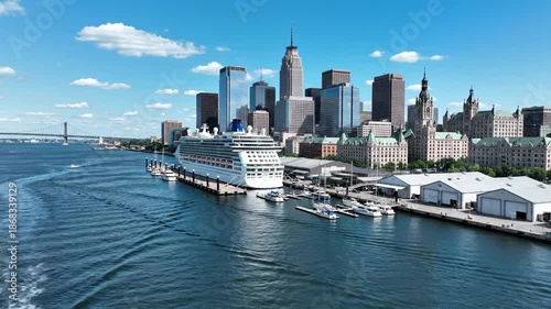 Cruise ship docked at urban harbor with city skyline and blue sky