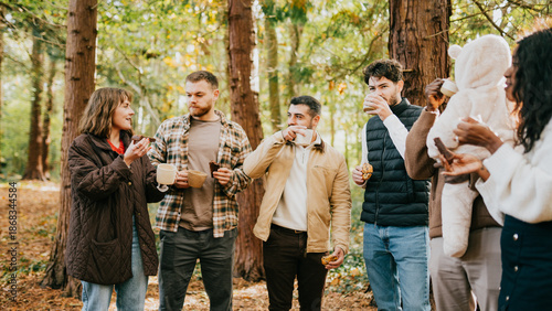 Billede på lærred A group of people are standing in a forest, some of them drinking coffee