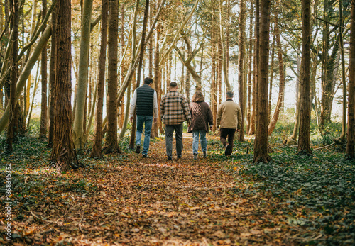 Foto A group of four people are walking through a forest