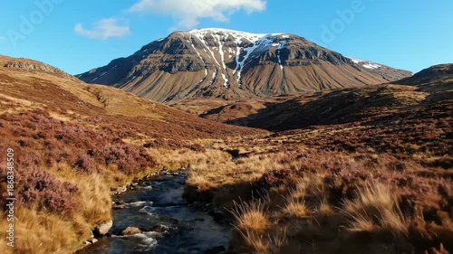 Mountain landscape with flowing stream under a blue sky scenic nature view