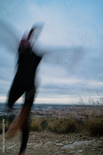 Blurred silhouette of a runner with a cityscape in the background