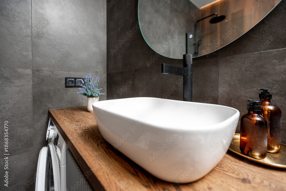 Fototapeta premium A bathroom with a sink, mirror, and a washer