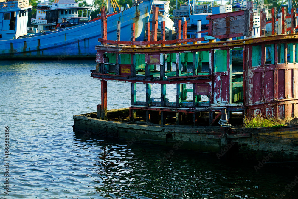 Fototapeta premium Weathered Boat Structure in Calm Waters with Colorful Reflections