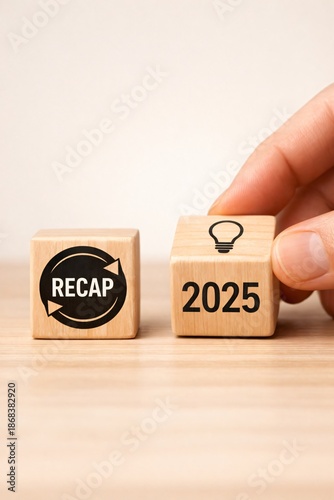 Wooden cubes showing RECAP and 2025 for strategic analysis, annual economic review and future agreement, corporate reports