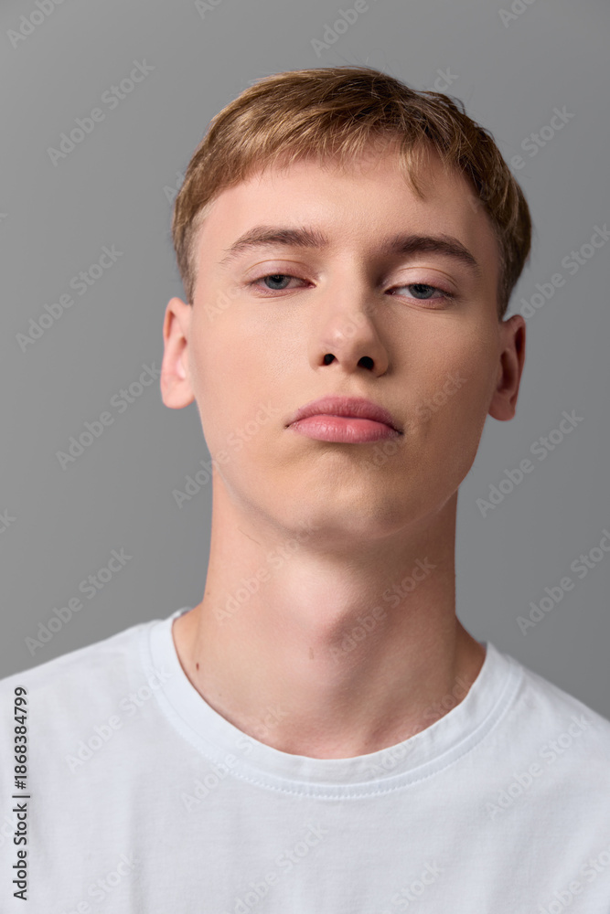 Fototapeta premium Man, young, face, white tshirt, neutral background, studio lighting, close up headshot with calm expression, minimal clean style for stock photography and versatile use in fashion and branding