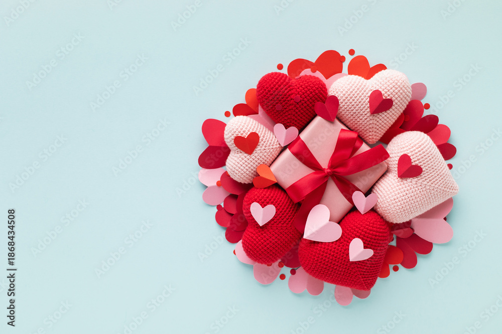 Fototapeta premium Valentine day gift box decorated with pink and red love hearts top view. Beautiful festive background for greeting card and dating invitation.