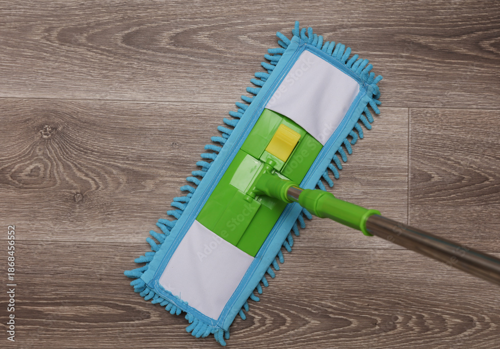 Fotografie Green plastic mop with rag on the floor