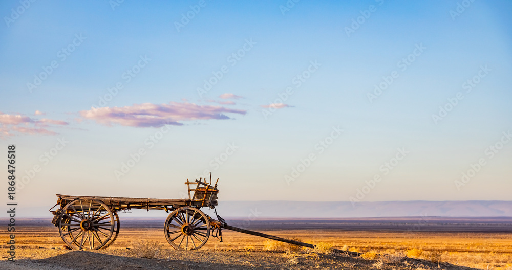 Fototapeta premium Vintage ox wagon abandoned in arid desert