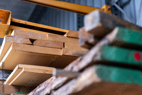 Vue de planches, plaquettes et palettes en bois empilées ou disposées, mettant en valeur les textures naturelles du matériau dans un contexte industriel ou de construction.