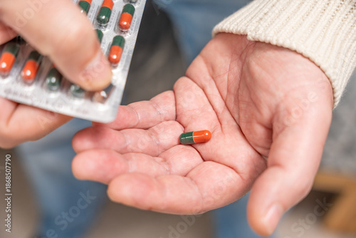 Quadro em tela Close-up of hands pushing a capsule from a blister pack into the palm