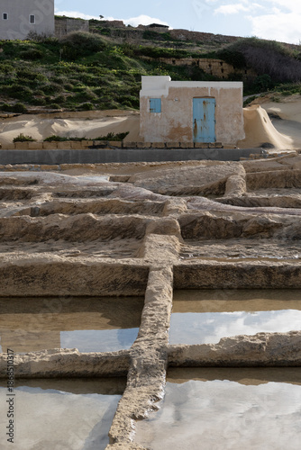 Abandoned stone salt pans form rectangular basins along the coast, showing traces of traditional salt production and weathered textures at Saline, Malta, on 29 December 2025.