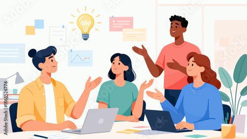 A group of people are sitting around a table with laptops and a light bulb. They are working together on a project