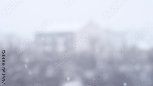 4K blurred snowfall with out of focus buildings in heavy winter whiteout