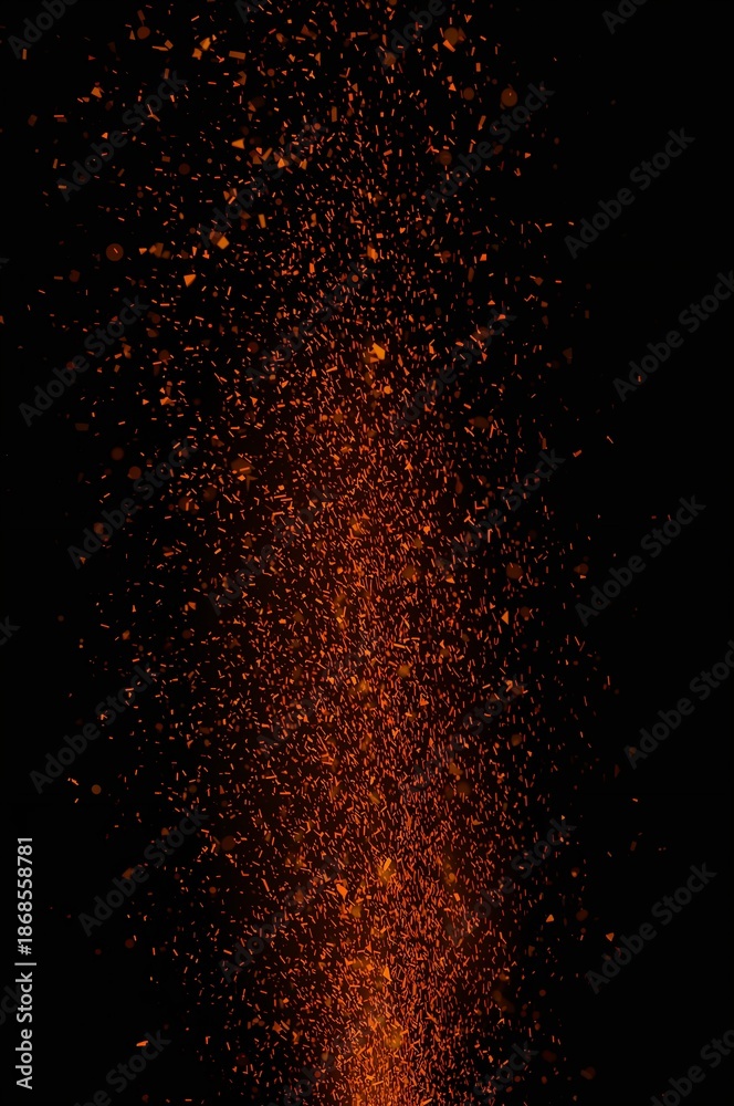 Fototapeta premium Intense orange and red sparks erupting upwards on a pure black background