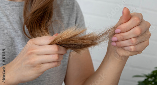 Tableau sur toile Woman looking at fallen hair in her hand