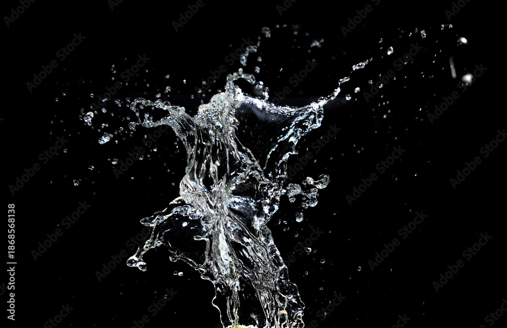 Fototapeta premium Captivating water splash, frozen in time, displaying dynamic movement and elegance against a dark background.