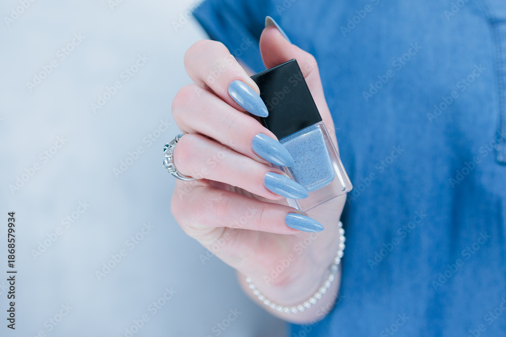 Fototapeta premium Woman's beautiful hand with long nails and light baby blue manicure 