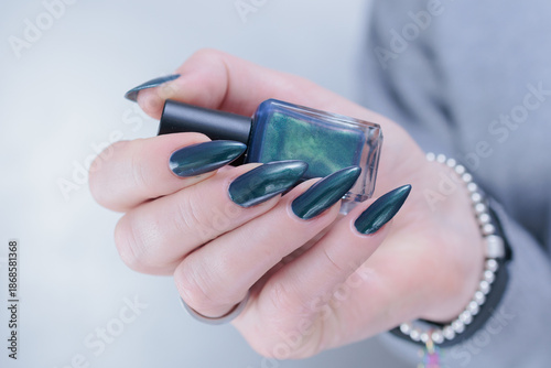 Foto Female hand with long nails and a green manicure