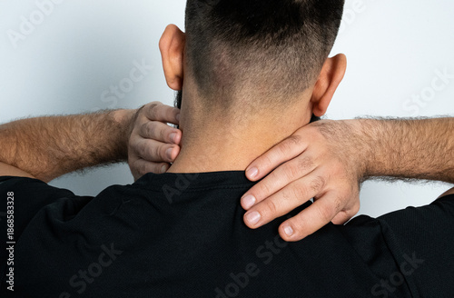 Man holding neck from behind, symbolizing pain, stress or muscle tension. Health and wellness concept.