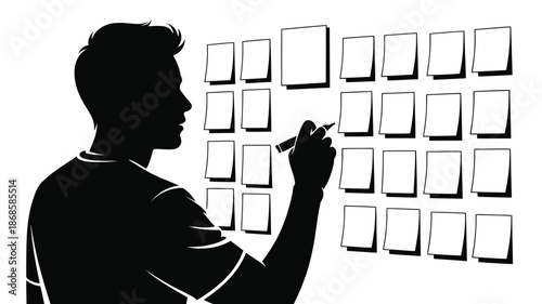 A mans silhouette is seen from the side as he writes on blank notes arranged on a wall