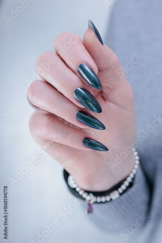 Obraz na płótnie Woman's beautiful hand with long nails and blue and green nail polish