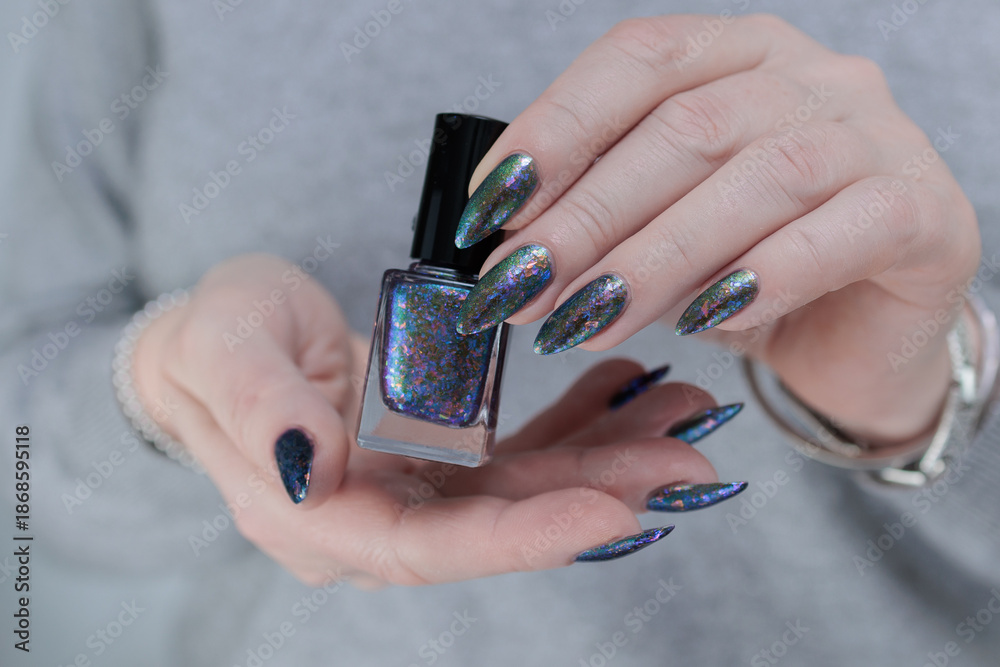 Fototapeta premium Female hand with long nails blue and silver manicure