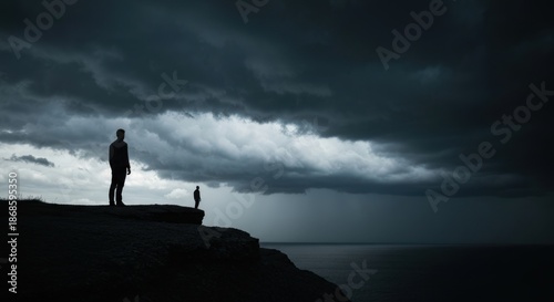 Two figures on a cliff edge facing a vast, stormy seascape