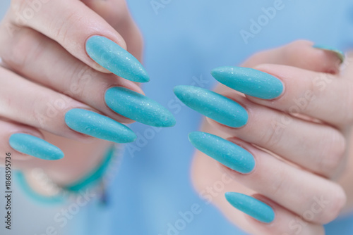 Konstfotografi Woman's beautiful hand with long nails and light baby blue manicure