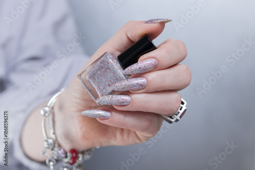 Female hand with long nails and silver pink and red manicure