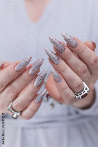 Female hand with long nails and silver pink and red manicure