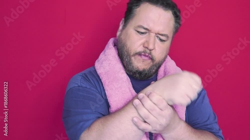A funny fat man doing fitness exercises. Red background.