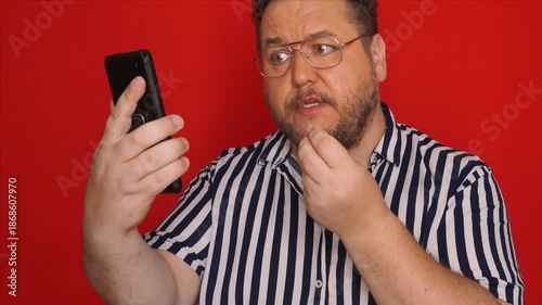 A grown man is angry and screaming. Red background.