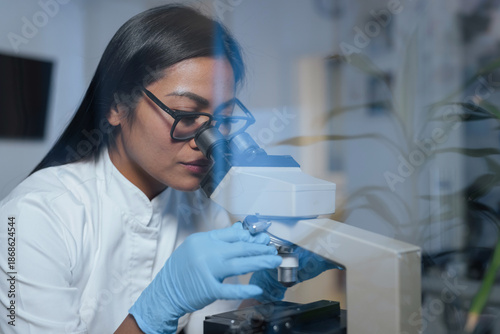 Принти на полотні A scientist examines samples under a microscope to conduct research in a biotechnology laboratory focused on medical science and biotechnology
