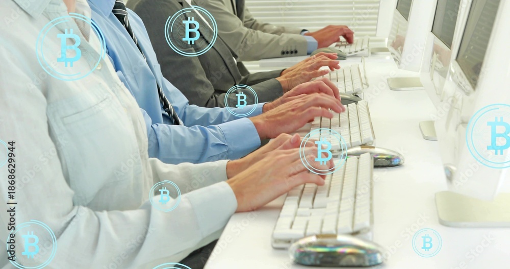 Fototapeta premium Typing coworkers hands at office desk with white keyboards, monitors and Bitcoin symbols in suits
