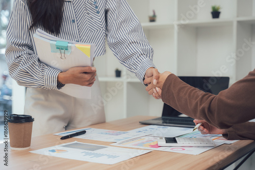 Fotografía Deal Agreement Handshake: The image captures a pivotal moment of collaboration as two individuals seal a business agreement, their hands clasped in a firm handshake