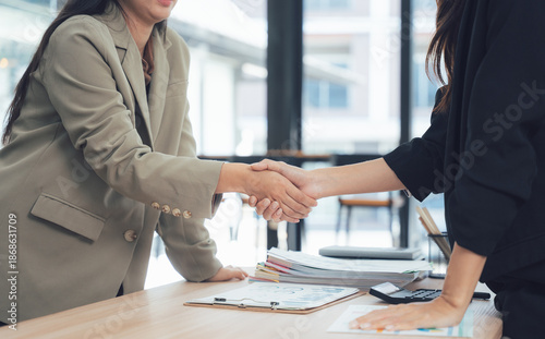 Quadro su tela Deal Seal: Capturing a pivotal moment of business accord, a pair of professional women clasp hands, symbolizing partnership and a mutual pledge of cooperation